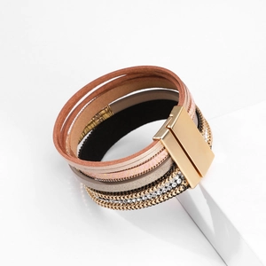 Detail van meerlaagse lederen wikkelarmband met kristallen en gouden magneetsluiting