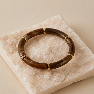 Close-up of Bohemian curved tube bracelet with marble texture and gold spacer beads