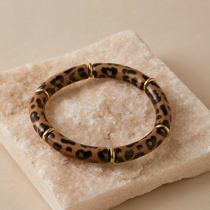 Detail of bohemian acrylic tube bracelet featuring leopard print patterns and gold spacers