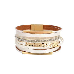 Détail du bracelet multicouche en cuir blanc avec barres dorées et cristaux étincelants