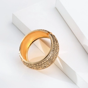 Bracciale rigido largo in oro vintage bohémien con incisioni floreali su sfondo in pietra bianca