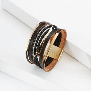 Détail de bracelet multicouche en cuir noir avec barre de cristal et fermoir magnétique