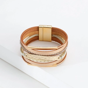 Détail d'un bracelet bohème multicouche en cuir avec fermoir magnétique doré et strass
