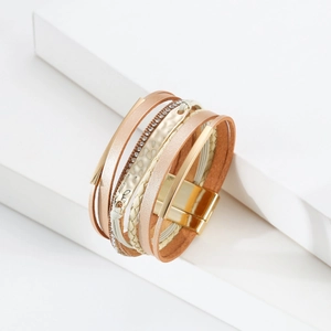 Détail d'un bracelet de cuir multicouche bohème avec fermoir magnétique et strass