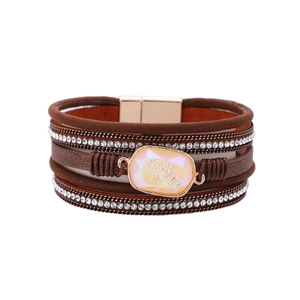 Detail of bohemian layered brown leather bracelet with crystal stones and magnetic clasp