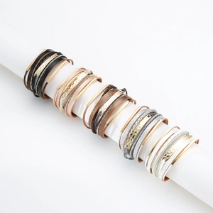 Détail de bracelets bohèmes multicouches en cuir avec tubes métalliques et strass