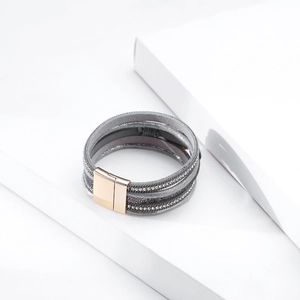 Detail of bohemian multilayer wrap bracelet with rhinestones and magnetic gold clasp