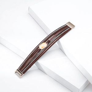 Detail of bohemian multilayer brown leather bracelet with yellow gemstone and crystals