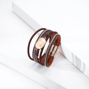 Detail of bohemian layered leather bracelet with pink crystal and golden magnetic clasp