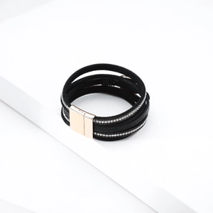 Detail of bohemian layered leather bracelet with crystals and gold magnetic buckle