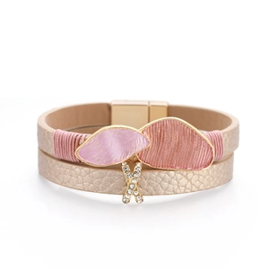 Detail of double-layer leather bracelet with pink enamel charm and magnetic clasp