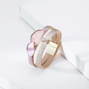 Close-up of layered leather bracelet with pink silk wrap and rhinestone metal clasp
