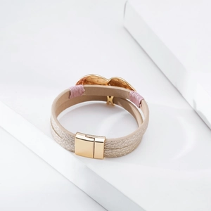 Detail of multi-layer leather bracelet with gold heart charm and magnetic clasp closure