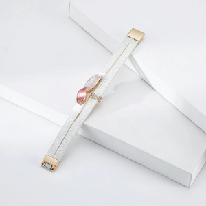 Close-up of double-layer white leather bracelet with X-shaped crystal charm and magnetic clasp