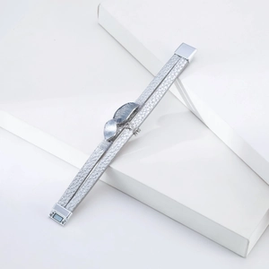 Detail of multi-layer silver bracelet with leaf charms and magnetic clasp on white stand