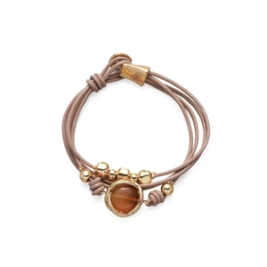 Detalle de pulsera multicapa de cuero con gema de ámbar y cuentas de metal doradas