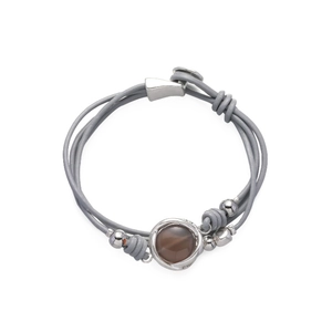 Detalle de una pulsera bohemia multicapa de cuero gris con cuentas y piedra de vidrio