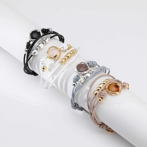 Set de cuatro pulseras tejidas multicapa con colgantes de cristal y metal pulido