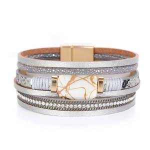 Close-up of multilayer leather bracelet with gray snakeskin print, faux stone, and rhinestones