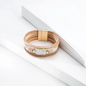 Detail of bohemian multilayer leather bracelet with marble stone and gold magnetic clasp