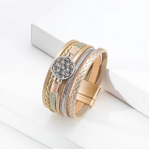 Detail of bohemian multilayer leather bracelet featuring geometric metal disc and magnetic clasp