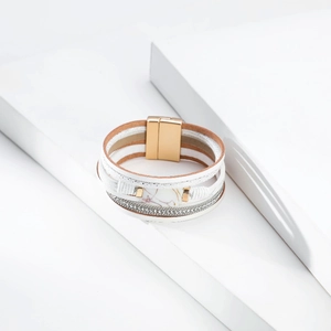 Macro detail of multi-layer leather bracelet with pearls, crystals and gold magnetic clasp