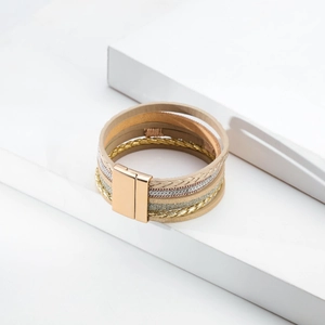 Detail of bohemian multilayer bracelet with gold magnetic clasp and textured leather strands