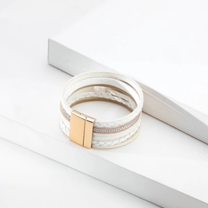 Detail of bohemian multilayer bracelet with white leather and gold magnetic clasp