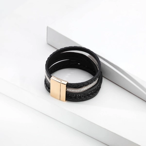 Detail of multi-layer leather bracelet with metallic chains and a gold magnetic clasp