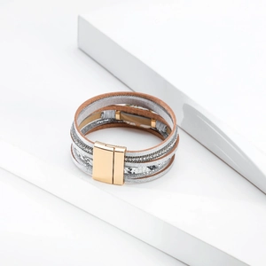 Detail view of multi-layer wrap bracelet with gold magnetic clasp and faux pearls