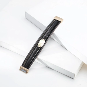 Detail view of multi-layer leather bracelet with rhinestone bands and marble bead