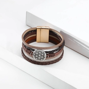 Detail of bohemian multilayer leather bracelet featuring a silver Tree of Life charm and magnetic clasp