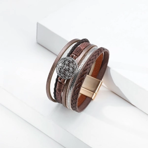 Macro detail of Bohemian multilayer leather bracelet with Tree of Life charm and magnetic clasp