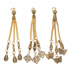 Detailed view of alloy prayer bead pendants with golden tassel chains and coin charms