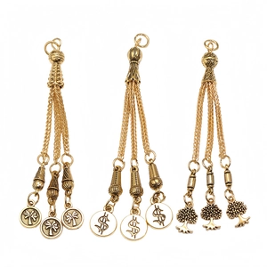 Detailed view of alloy tassel charms with palm tree, dollar sign, and leaf designs