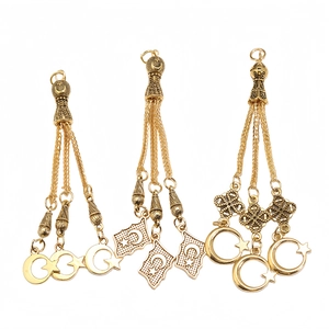 Close-up of golden alloy Tasbih tassel pendants with moon and star charms for prayer beads