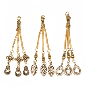 Detailed view of alloy prayer bead tassel pendants with vintage gold finish and engravings