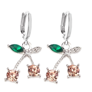 Macro shot of cherry earrings with champagne zircons and green leaf crystal details