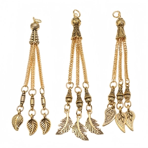 Close-up of vintage gold alloy prayer bead tassels with leaf-shaped metal charms