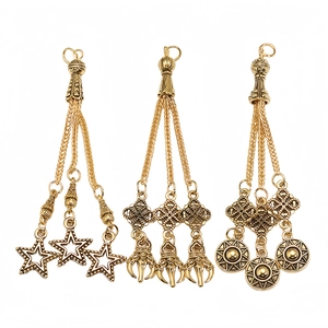 Detailed view of three vintage gold alloy tassels with ethnic patterns and star charms