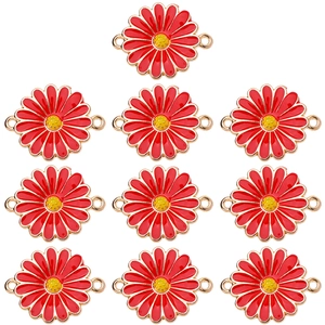 Close-up of red enamel daisy charms with gold metal edges for DIY jewelry making