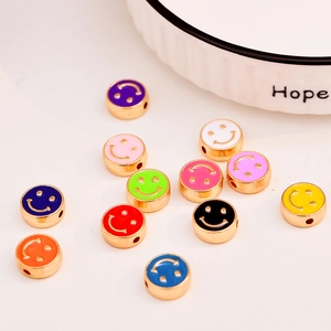 Macro view of colorful enamel smiley face beads with gold plated rims for DIY jewelry