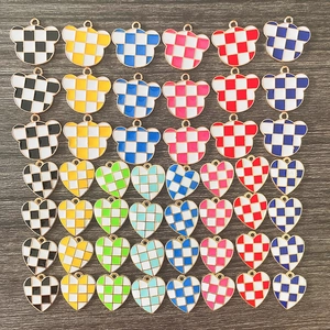 Macro detail of checkered heart and bear charms with colorful oil drip enamel finish
