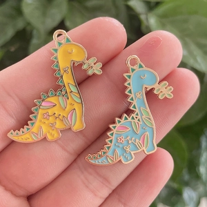 Detailansicht der gelben und blauen Emaille-Dinosaurier-Anhänger mit Blumenmuster