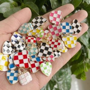 Macro view of colorful checkerboard oil-drip heart and bear charms for DIY jewelry making