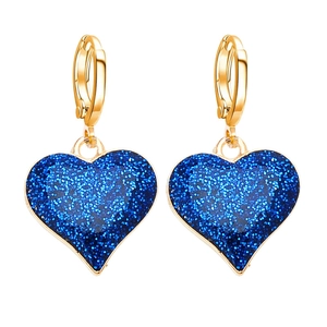 Nahaufnahme goldener Creolen mit funkelnden blauen Herzanhängern und glitzerndem Finish