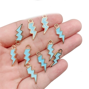 Detailed close-up of blue enamel lightning bolt pendants with gold metal frames