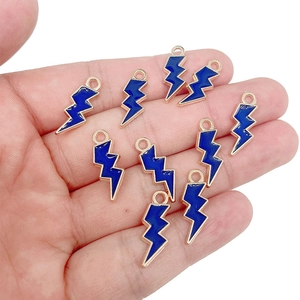 Close-up of royal blue enamel lightning bolt charms held in hand for scale and detail