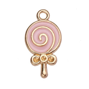Macro shot of pink enamel lollipop charm with golden metal details and hanging loop