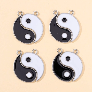 Close-up of four yin yang enamel heart pendants with double metal loops for DIY jewelry